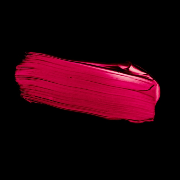 Pink lipstick brush stroke texture isolated on black background