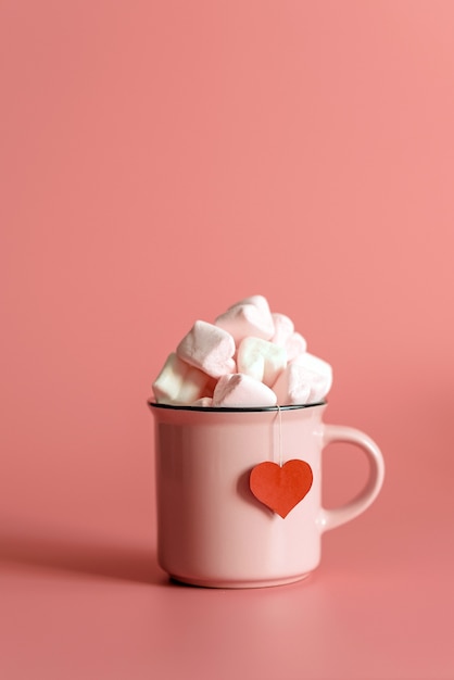 Pink mug filled with marshmallows in the form of hearts