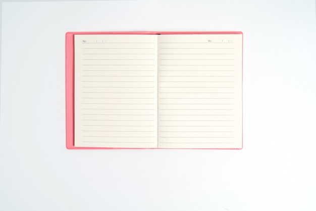 Pink notebook on white desk. Business minimal concept for women. Flat lay, top view, copy space