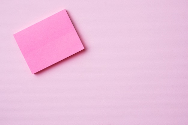 Pink Notepad paper clip and pencil on pink