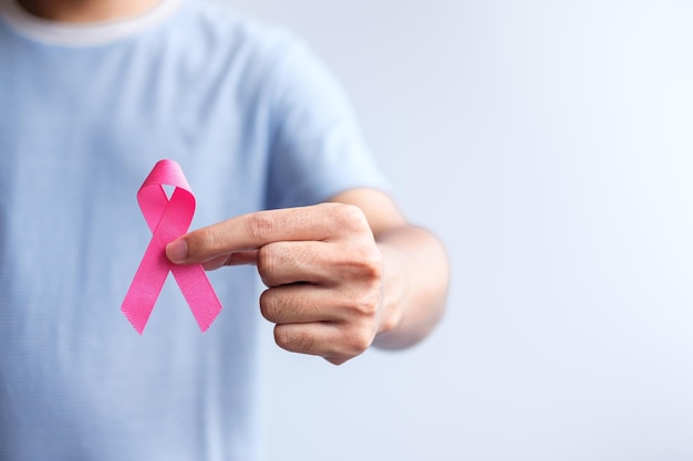 Pink October Breast Cancer Awareness month man hold pink Ribbon for support people life and illness National cancer survivors month Mother and World cancer day concept