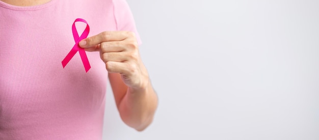 Pink October Breast Cancer Awareness month woman hand hold pink Ribbon and wear shirt for support people life and illness National cancer survivors month Mother and World cancer day concept