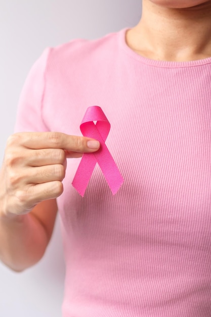 Pink October Breast Cancer Awareness month woman hand hold pink Ribbon and wear shirt for support people life and illness National cancer survivors month Mother and World cancer day concept