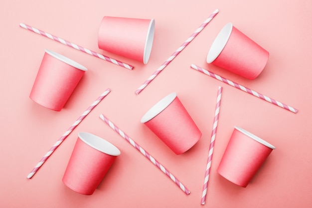 Pink paper cups and pink-white straw on pink