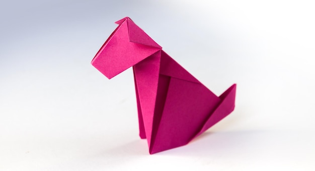 Pink paper dog origami isolated on a white background