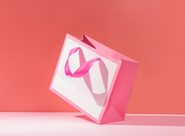 Pink paper gift bag on a bright background