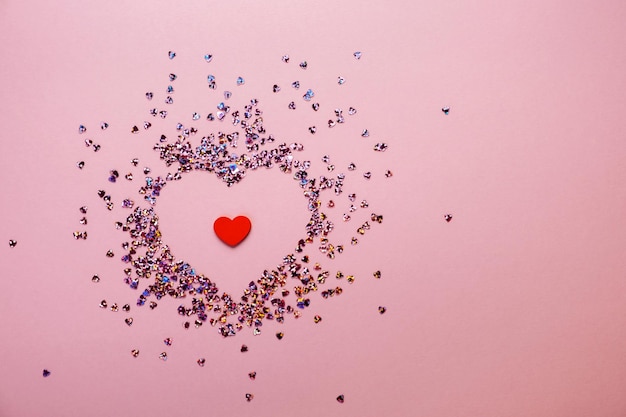 Pink pastel background with small hearts confetti flatlay top view copy space