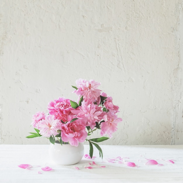 Pink  peonies  on background old white wall