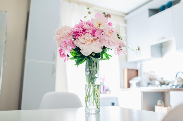 Pink peonies modern kitchen design interior of white and silver kitchen decorated with flowers