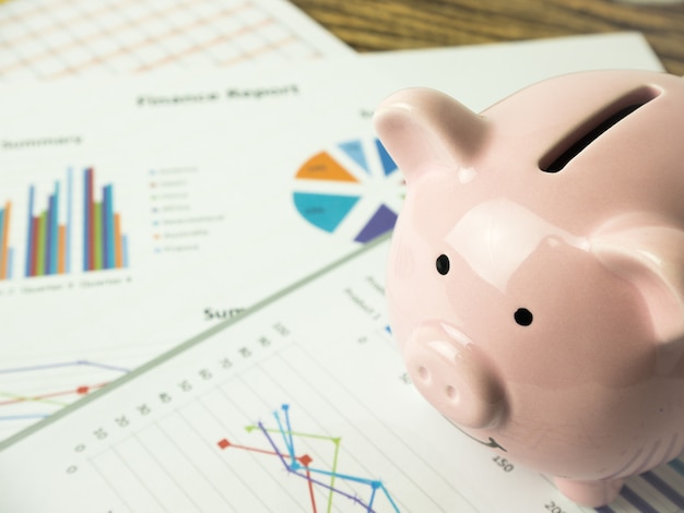 Pink piggy bank on business graph, finances and economy concept