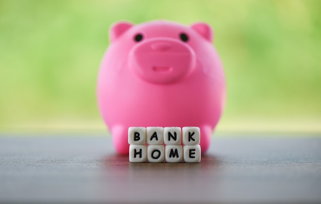 Photo pink piggy bank and dices words of bank home