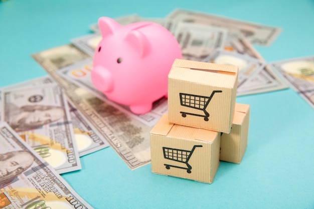 Pink piggy bank, three delievery box and dollar banknotes on blue.