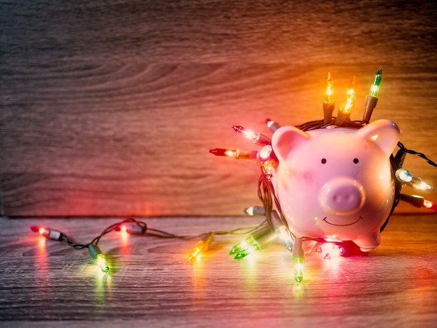 Pink piggy bank with Party lights, Enjoy savings for the holidays concept.