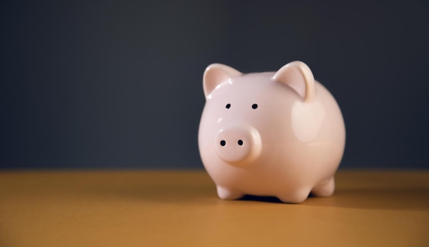 Pink piggy bank on wooden table. The concept of storage