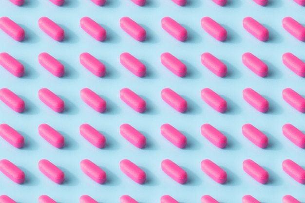 Pink pills seamless pattern on blue