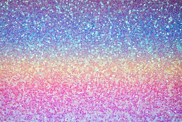 Pink purple and blue glitter texture shiny sequins abstract background with blur party baby blur