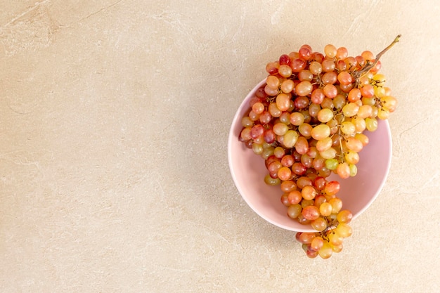 Pink raisins grapes, lying on a stone in the bright sun, autumn grapes.