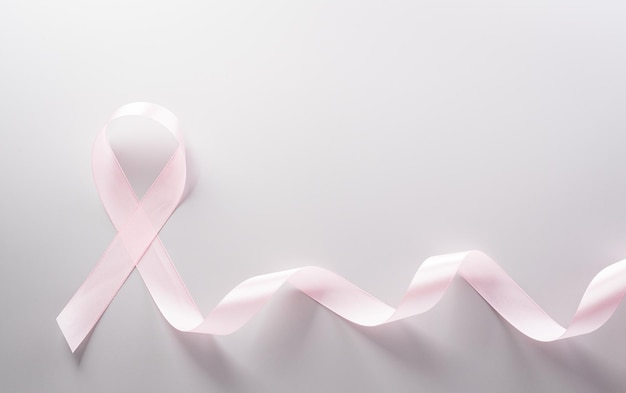 Pink ribbon on pastel paper background for supporting breast cancer awareness month campaign