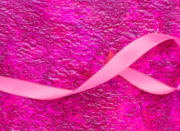 Pink ribbon on pink background