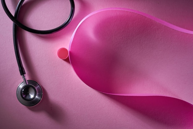 Pink ribbon and stethoscope on a pink background