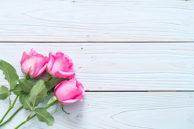 pink rose in vase on wood background