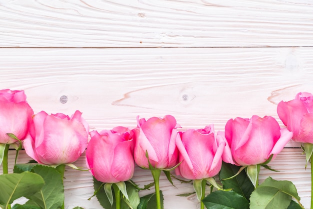 pink rose in vase on wood background