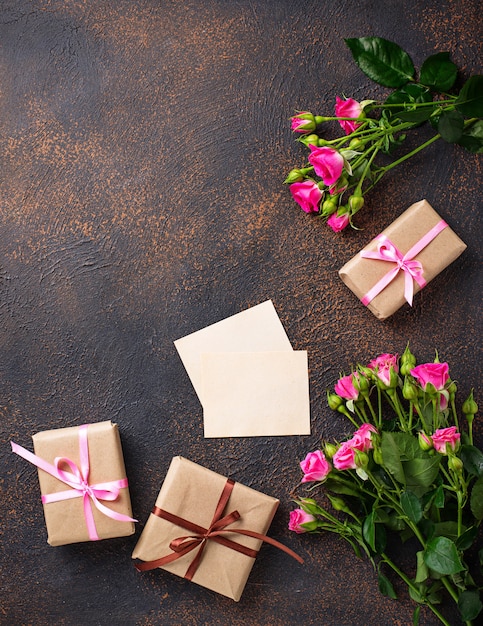 Pink roses, gift boxes and greeting card