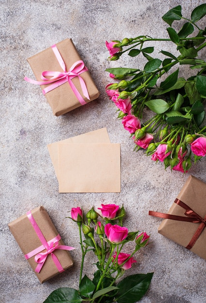 Pink roses, gift boxes and greeting card