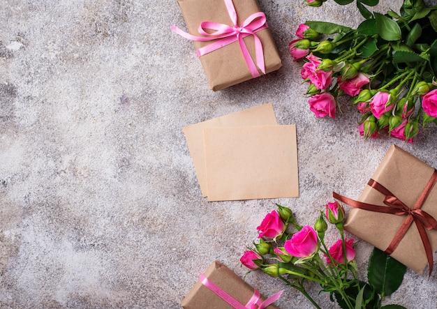 Pink roses, gift boxes and greeting card