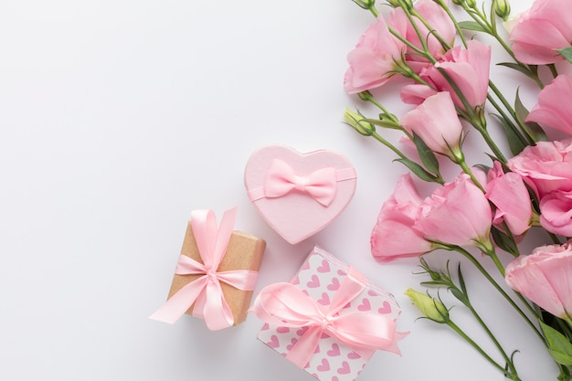 Pink roses and gift boxes on white background