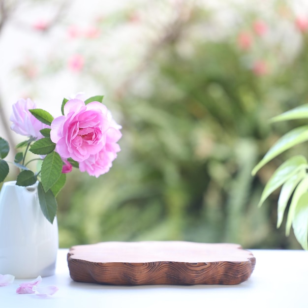 Pink roses in small vase with wooden board plate