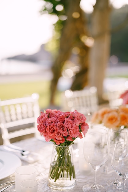 Pink roses on a table decorated for a wedding reception