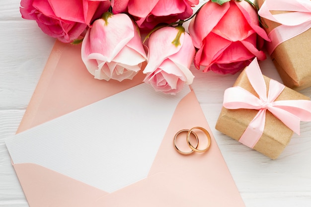 Pink roses and wedding rings on envelope