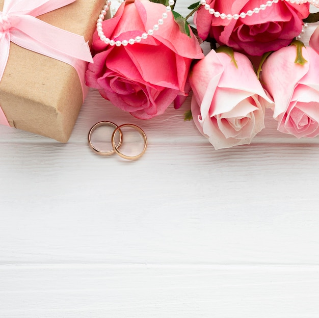 Pink roses and wedding rings with pearls