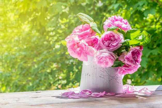 Pink roses in a white vase on a sunny spring dayBulgarian Damascena RoseSpace for textToned