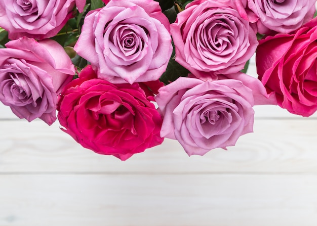 Pink roses on wooden background