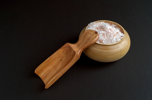 Photo pink salt in wooden bowl.