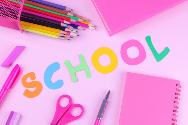 Pink school  supplies with an inscription  on a  pink background