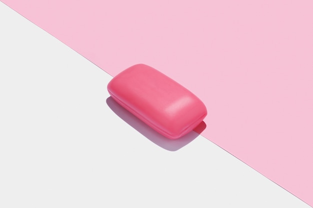 Pink soap bar in center of white and pink background