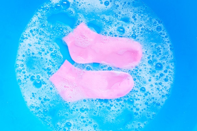 Pink  socks soaking in powder detergent water dissolution.