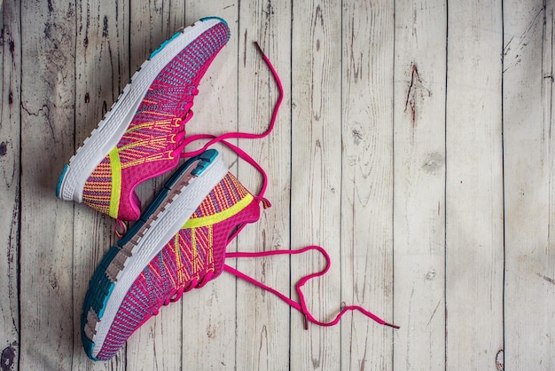 Pink sport shoes Sneakers on a gray wooden table Top view with copy space