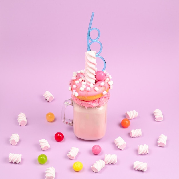 Pink strawberry freakshake with marshmallow and sweets