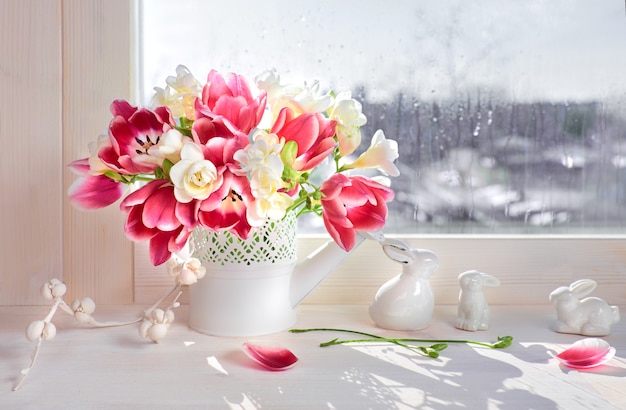 Pink tulips and white freesia flowers with ceramic 