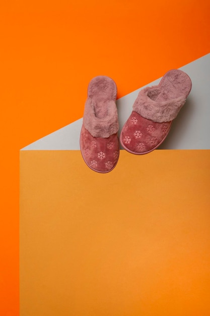 Pink warm women's slippers on a colored background