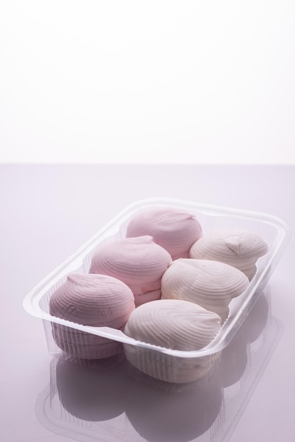 Pink and white marshmallows packed on a white background