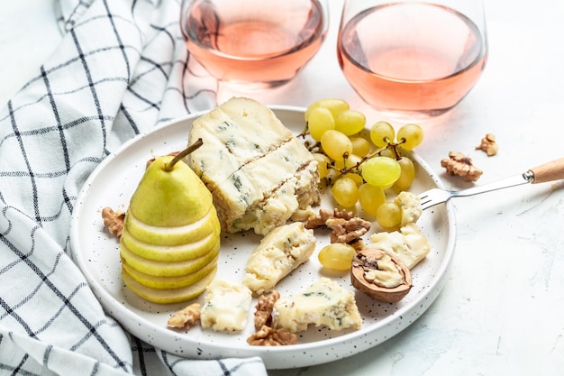 Pink wine rose aged cheese Camembert cheese nuts honey grapes Pears blue cheese glasses of wine French cuisine Delicious food wine snacks assorted