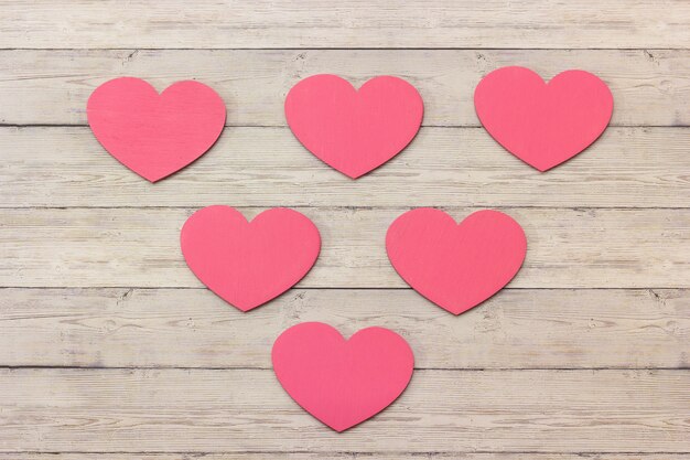 Pink wooden hearts on a wooden background