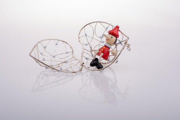 Pinocchio doll sitting on a heart shaped cage