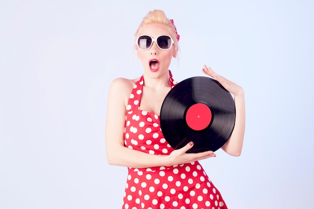 Pinup girl in vintage dress holding a vinyl records