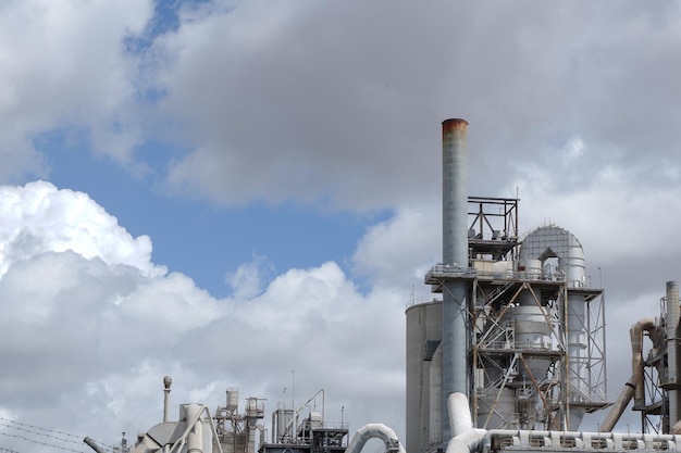 Pipe of the cement factory against moody sky Production site industrial workspace